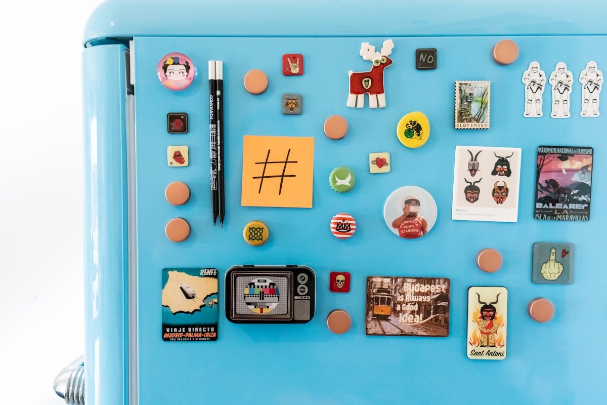 Blue refrigerator covered with decorative magnets and notes